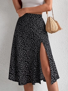Detail shot of the high side slit and daisy floral print on this black summer midi skirt