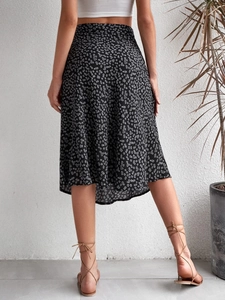 Rear view of a black floral midi skirt with a side slit and A-line silhouette