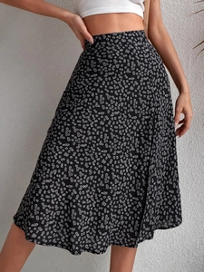 Close-up of lightweight black floral skirt with white daisy pattern and side slit detail