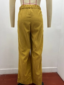 Detail view of ginger corduroy wide-leg trousers featuring elastic high waist design