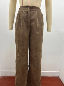 Detail of brown corduroy trousers showing ribbed texture and amber button waist closure