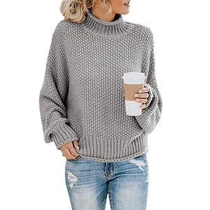 Detalle de jersey gris de punto grueso con cuello alto y puños acanalados suaves