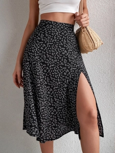 Detail view of the high side slit and white floral print on a black midi skirt