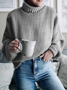 Detalle de jersey de punto grueso gris con cuello alto y puños acanalados texturizados