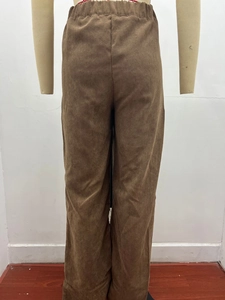 Detailed macro view of the brown corduroy fabric texture and elastic high waistband