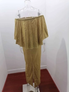 Detail of glittery gold off-shoulder evening dress with layered ruffles and back slit