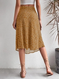 Back view of mustard yellow floral midi skirt with side slit and slim fit silhouette