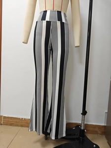 Detail showing high-waisted flared trousers with vertical black and white stripe pattern