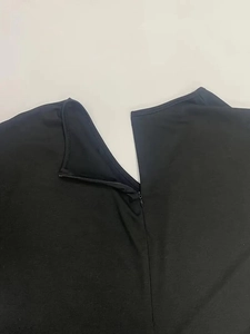 Close-up of the invisible zipper on the back of a black V-neck jumpsuit for women