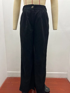 Close-up of high-waist black corduroy trousers with vertical texture and button detail