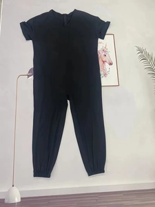 Detail of a black V-neck short sleeve jumpsuit with back zipper and tapered elastic cuffs