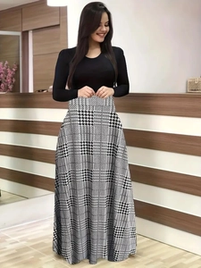 Détail d'une robe longue élégante à taille haute avec patchwork en pied-de-poule et manches