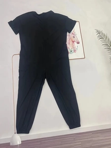Detail view of black short sleeve jumpsuit with elastic cuffs on a home studio background