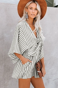 Detail view of striped v-neck romper with waist tie and side pockets in linen fabric