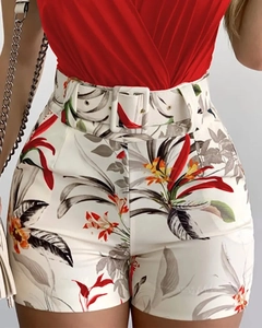 Detail of red V-neck camisole paired with tropical floral print high-waisted shorts with belt