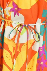 Détail de la robe d'été à imprimé floral tropical avec ceinture assortie et tissu orange vif