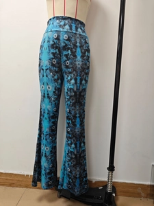 Detail view of high-waisted flared trousers with blue and black mandala floral patterns