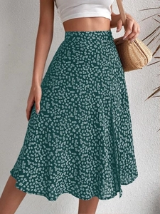 Detail of high-waist dark green floral midi skirt with white daisy pattern and side slit