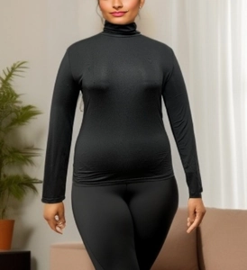 Detail of slim-fit black turtleneck long sleeve knitted top for women in cozy home setting
