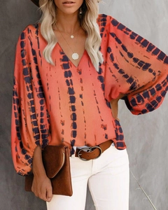 Nahaufnahme der V-Ausschnitt Bluse mit orange-blauem Batikdruck und Puffärmeln