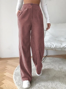 Detail view of pink corduroy high-waisted pants with button closure and straight wide-leg cut