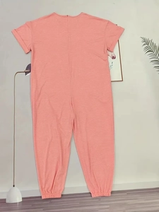 Detail view of pink coral jumpsuit featuring a back zipper and cuffed sleeves design
