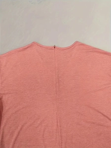 Detail of the pink jumpsuit featuring back zipper closure and textured knit fabric