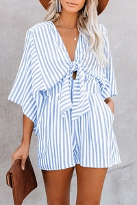 Detail of blue striped romper featuring a deep V-neckline and front bow tie waist