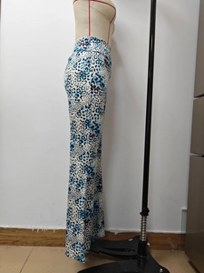 Detail of high waisted flared trousers featuring blue leopard print and slim fit design