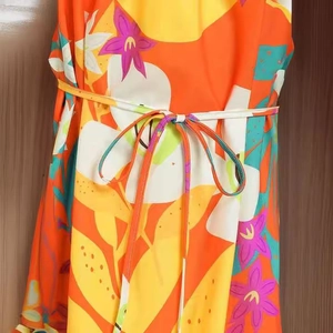 Robe d'été bohème à imprimé floral avec ceinture sur un fond en bois sombre