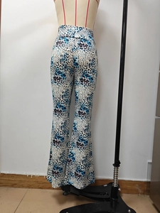 Detail view of high waisted bell bottom pants with blue and black leopard print on mannequin