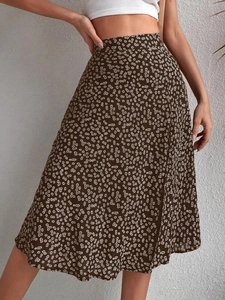 Detailed close-up of a high-waisted floral A-line skirt with white daisy print and slit design