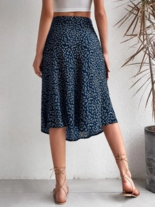 Back view of a navy floral midi skirt with side slit and white polka dot pattern