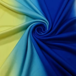 Detail of silk-like gradient fabric from yellow to blue with soft satin texture