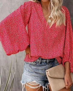 Detail eines V-Ausschnitt Oberteils mit Blumendruck, Laternenärmeln und Jeans-Shorts