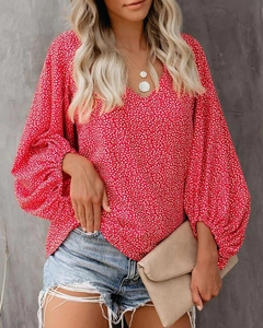 Detail einer roten Blumenbluse mit V-Ausschnitt und lässigen Laternenärmeln