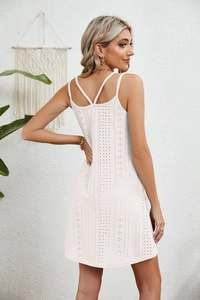 Detail view of the white eyelet cotton dress featuring an elegant crisscross backless design