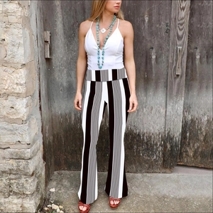 Detail of high waisted flare pants featuring bold black and white vertical stripe pattern