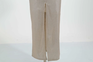 Detailed macro view of the split hem on a glittering champagne knit evening dress