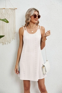 Close-up of elegant eyelet embroidery texture and delicate double straps on the summer dress