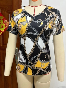 Close-up of women's V-neck T-shirt featuring golden chain print and color-block design