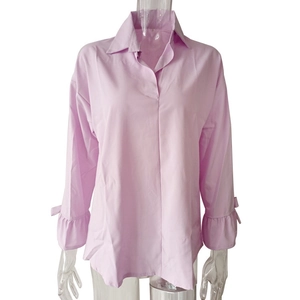 Detail of lavender shirt showing ruffle cuffs and bow ties with a smooth fabric texture