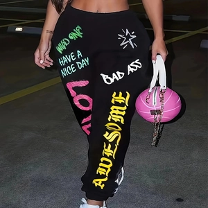 Détail d'un pantalon de jogging noir avec imprimés graffiti colorés et ourlet élastique