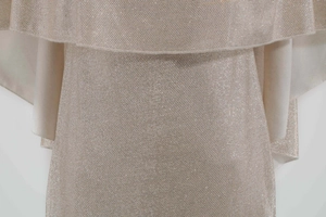 Close-up of sparkling champagne gold fabric with elegant ruffles on the dress