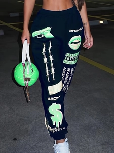 Detail of black joggers with neon green graphic prints and matching basketball bag