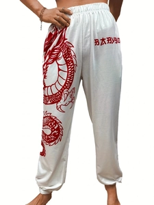 Detail view of white jogger pants with red dragon print and elastic waistband