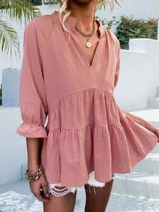 Detail of dusty pink V-neck textured cotton blouse with elastic ruffled cuffs and pleats