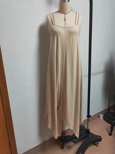 Detail eines beigen rückenfreien Midikleides mit Strickstruktur und drapiertem Saum