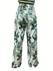 Rear view of high waisted wide leg pants with green tropical leaf print and smocked waist