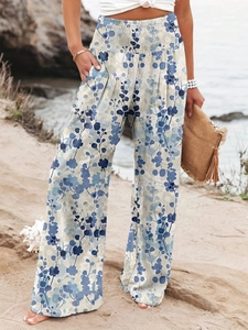 Close-up of wide smocked waistband and blue leaf print on summer beach trousers